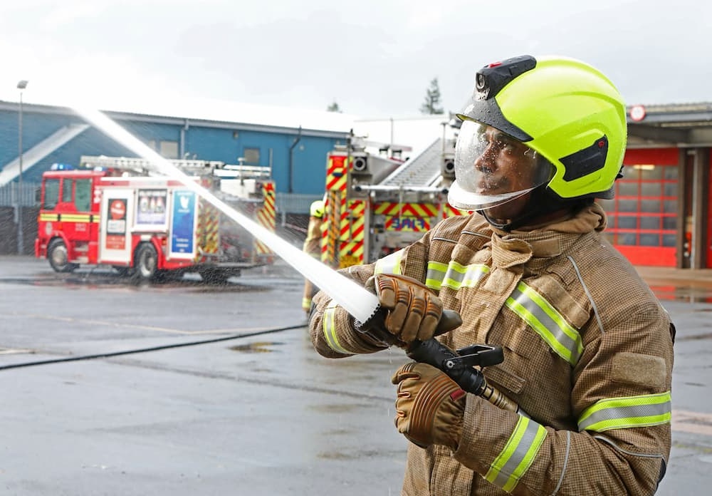 Trainee Firefighter spraying water with a hose reel