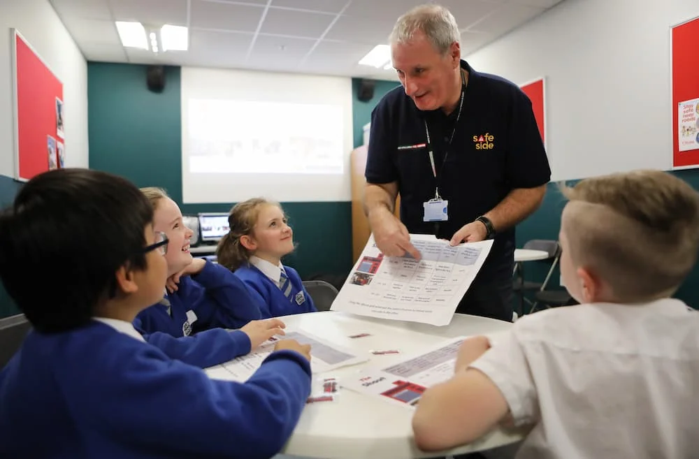 A safeside volunteer working with some children on fire safety