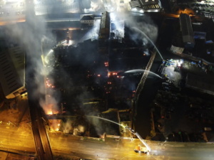 Aerial photograph of fire appliances and hydraulic platforms tackling the fire.