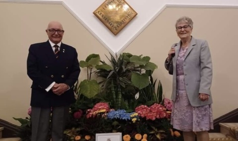 Harry and Sheila Dennick standing on some stairs at Birmingham's Council House with a certificate