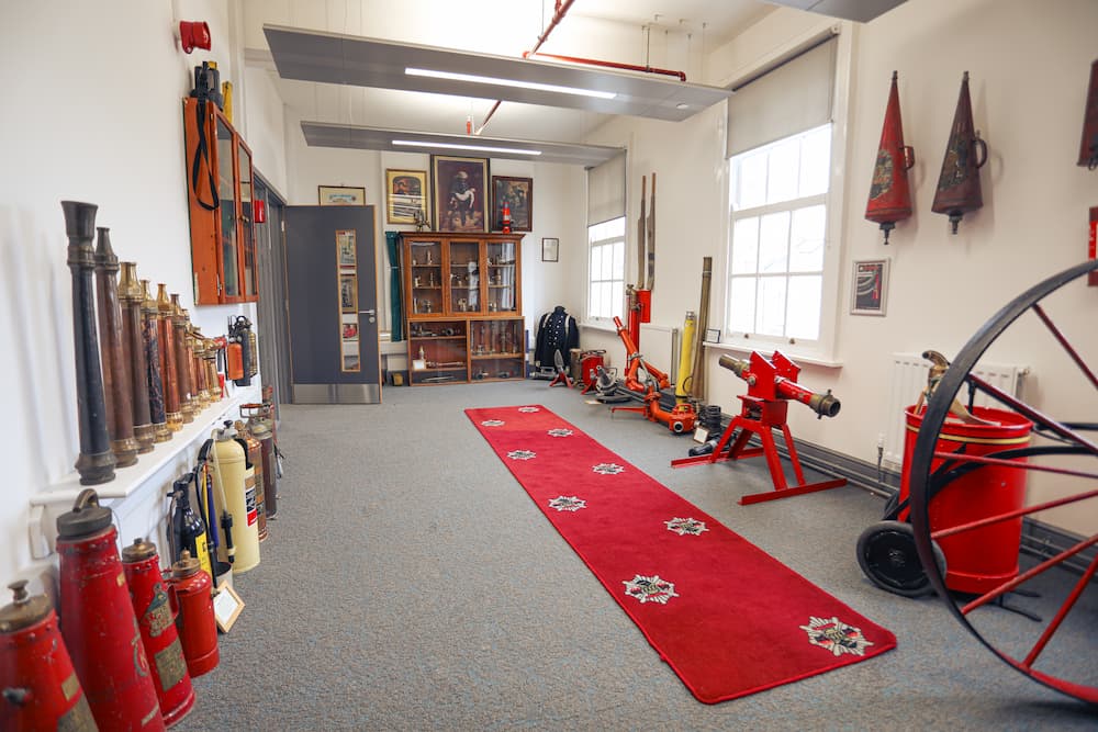 A range of clothing, tools, and equipment used in firefighting over the years in a room the Heritage Group Museum