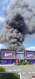 A plume of smoke above a retail shopping store