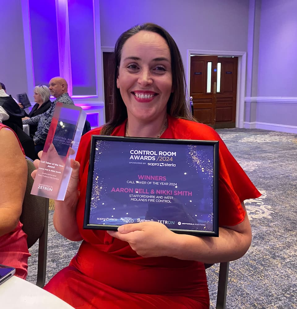 Firefighter (Control) Nikki Smith poses with a certificate after winning an award