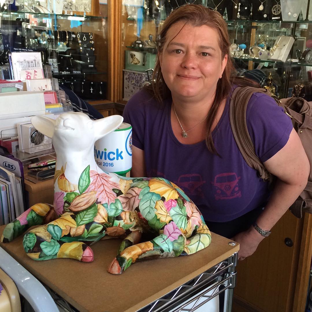 A photo of Sue Brookin smiling in a shop.