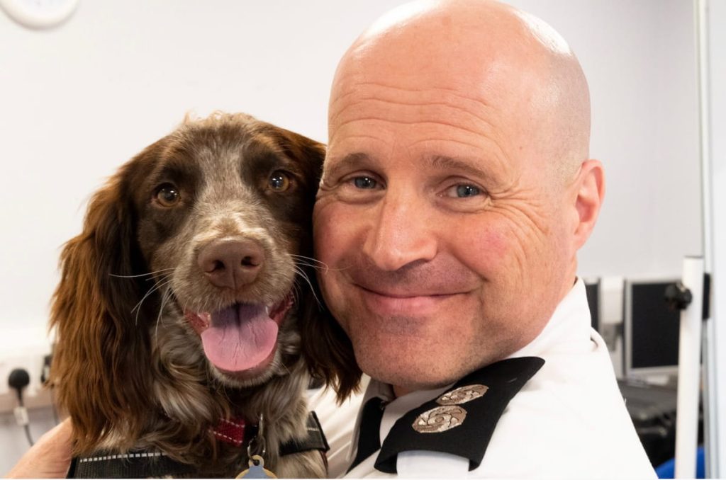 A close up of fire investigator Alex Daw smiling with fire dog Giddy