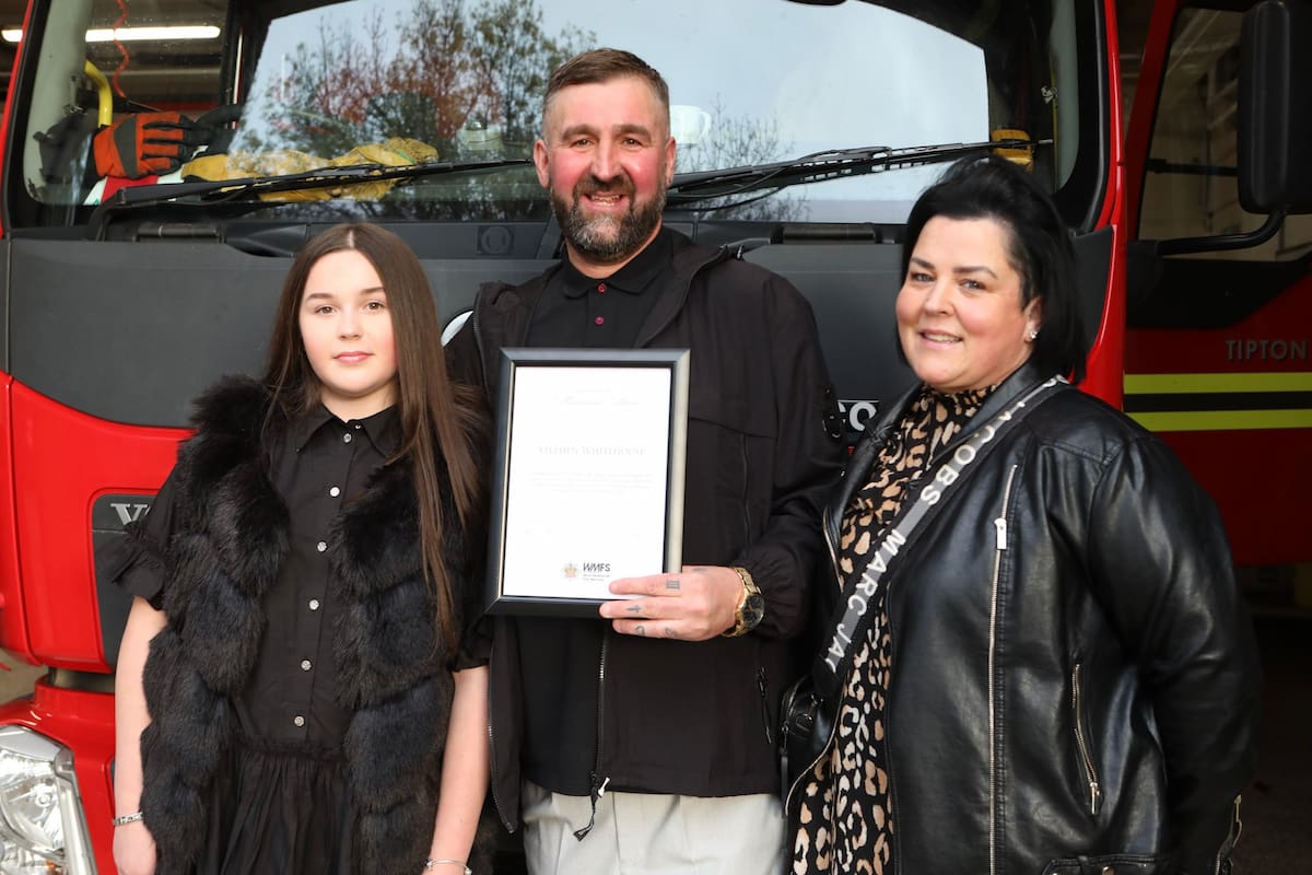 Steve Whitehouse poses with his family in front of a fire engine after receiving his Certificate of Meritorious Action at Tipton Fire Station.