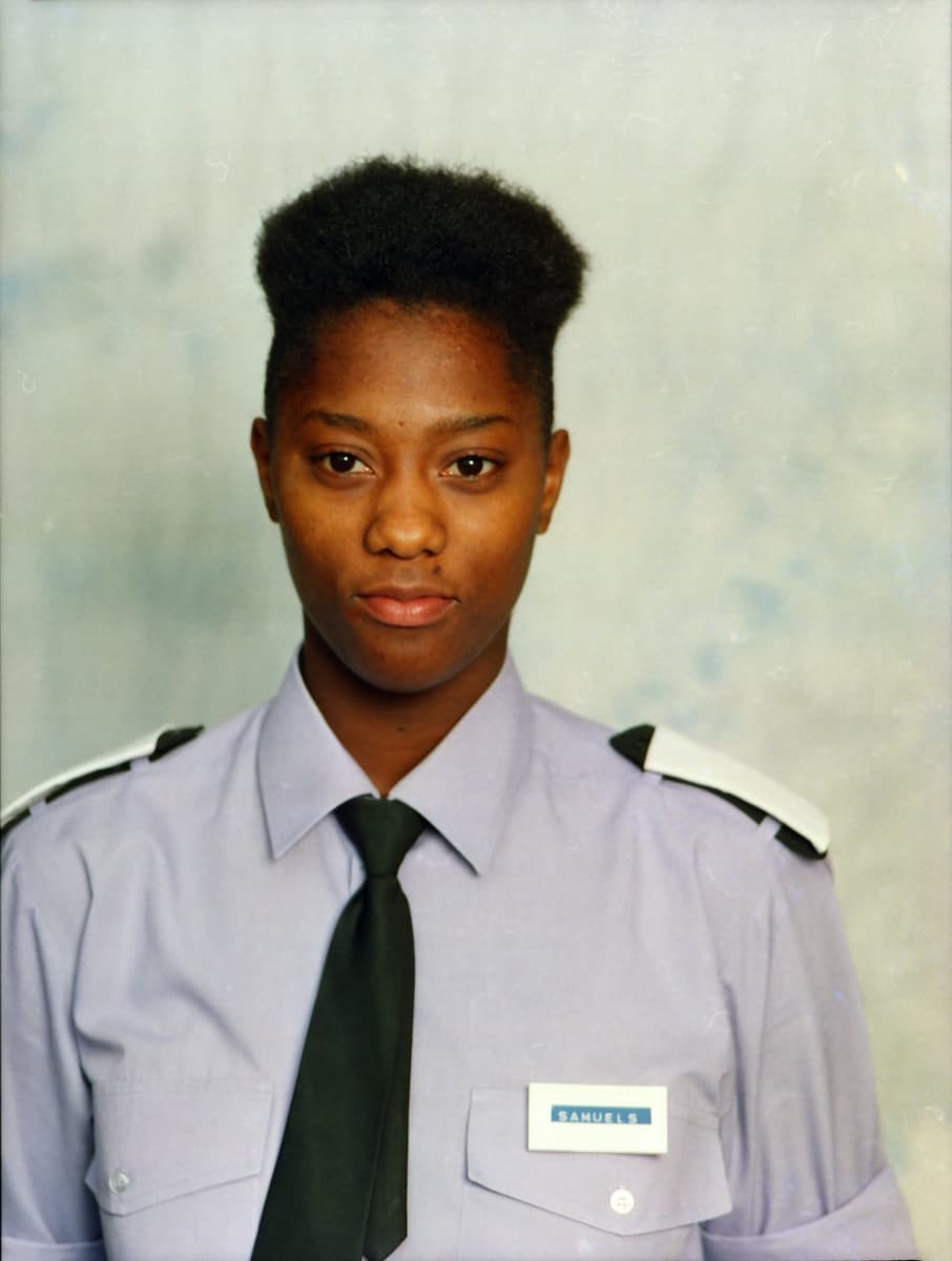 Portrait of a younger Sam Samuels in fire service uniform, looking directly at the camera, representing her early years with the West Midlands Fire Service.