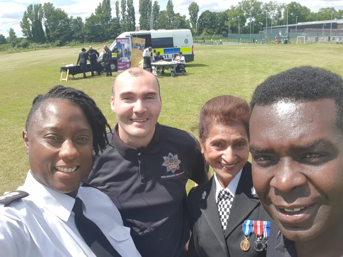 Sam Samuels and three colleagues from West Midlands Fire Service and West Midlands Police, taking a selfie outdoors at a community event.